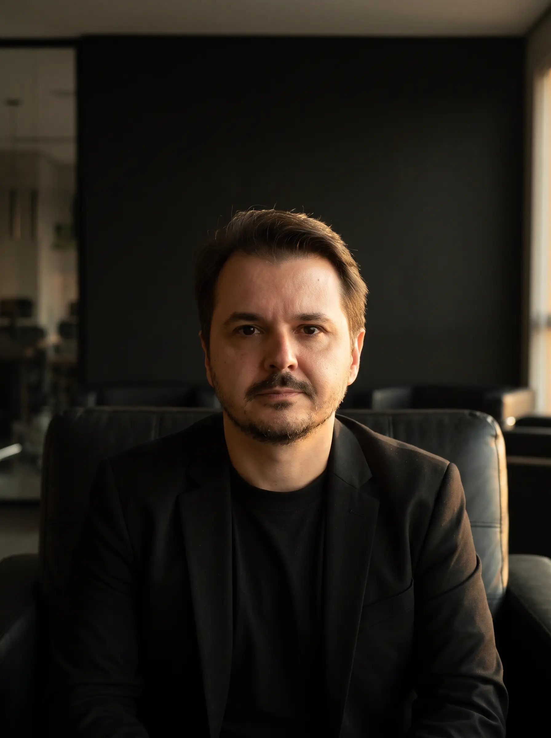 Cristian Noldin sentado numa poltrona, com luz de fim de tarde vindo da janela